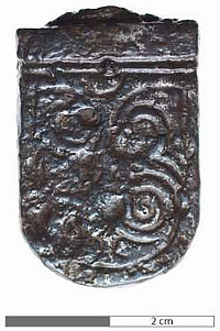 Riemenzunge einer Gürtelgarnitur. Ursprünglich waren in die spiralförmigen Vertiefungen Silberstreifen eingelegt (frühes 7. Jahrhundert).